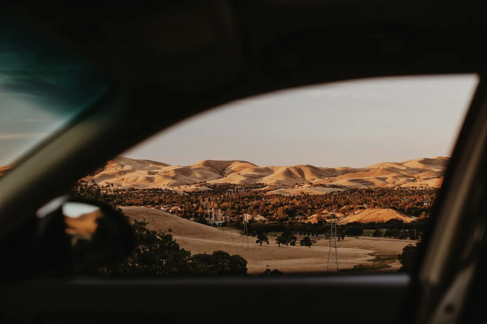 View of hills through a car window from a dark cabin